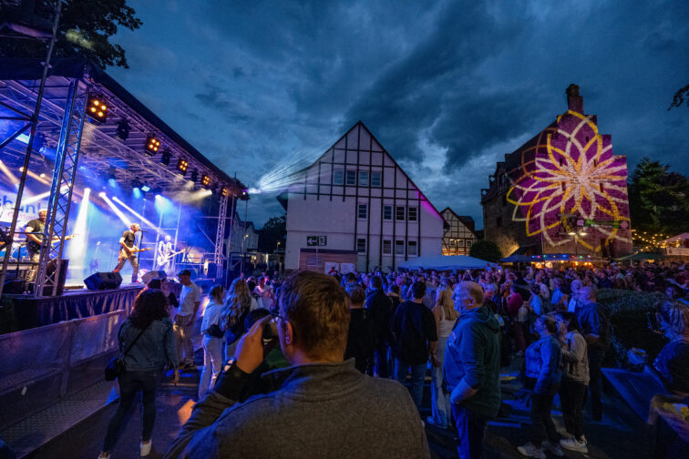 Stadtfest abends mit Bühne und Lichtprojektionen auf die umliegenden Häuser